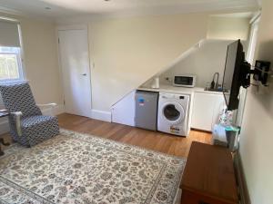 a living room with a washing machine and a staircase at Garden flat, NORTH SYDNEY in Sydney