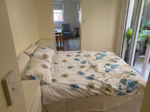 a bed with a floral comforter in a room at Garden flat, NORTH SYDNEY in Sydney
