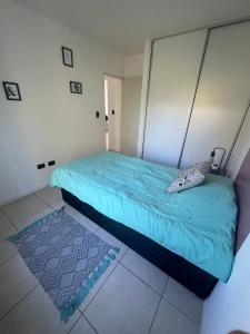 1 dormitorio con cama con sábanas azules y alfombra en Sarratea Guest en Godoy Cruz