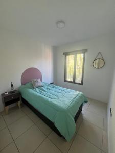 a bedroom with a bed and a window at Sarratea Guest in Godoy Cruz