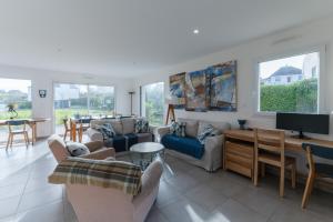 a living room with couches and a flat screen tv at TY KREIZH - Maison neuve avec piscine proche mer in Saint-Pabu