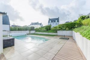 a swimming pool in the backyard of a house at TY KREIZH - Maison neuve avec piscine proche mer in Saint-Pabu