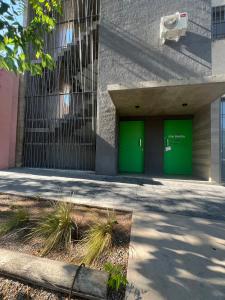 un edificio con puertas verdes a un lado en Sarratea Guest en Godoy Cruz