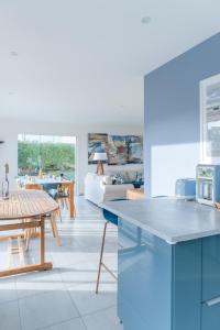 a kitchen and living room with a table and a couch at TY KREIZH - Maison neuve avec piscine proche mer in Saint-Pabu