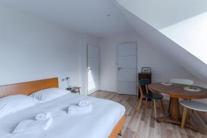 a bedroom with a bed and a small table at TY KREIZH - Maison neuve avec piscine proche mer in Saint-Pabu +41 photos