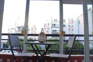 - Balcón con ventanas, mesa y sillas en NightInSevilla Juglar Free parking, en Sevilla