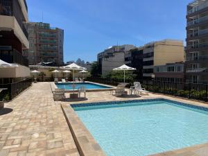 a swimming pool with chairs and umbrellas on a building at Arpoador Vista Mar in Rio de Janeiro