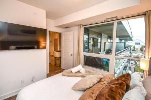 ein Schlafzimmer mit einem Bett und einem großen Fenster in der Unterkunft Sauna*King Bed*Fireplace*SmartTV in Innisfil