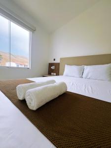 1 dormitorio con 1 cama blanca grande y ventana grande en DM Hoteles Asia, en Asia