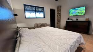 Un dormitorio con una cama grande y una ventana en La Peña Hotel Boutique & SPA, en Cuetzalán del Progreso