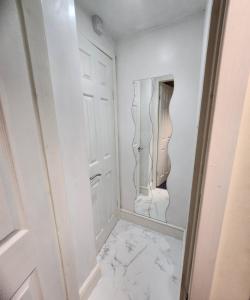 a white hallway with a mirror and a marble floor at Stylish Modern 1-Bed Apartment in Prime Solihull Town Centre in Solihull +8 photos