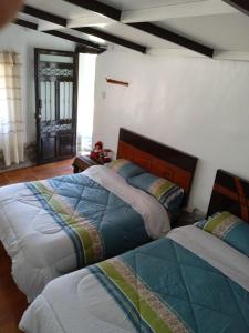 a bedroom with two beds in a room at casa montañista lodge & camping in Huaraz