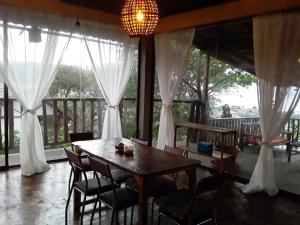 a dining room with a table and chairs and curtains at Maremonti Vacation Rental in Puerto López +70 photos