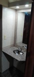 uma casa de banho com um lavatório e um espelho em las campanitas em Paso de la Patria
