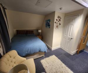 a bedroom with a blue bed and a chair at Flat in Solihull town centre, 2 Big rooms in Solihull