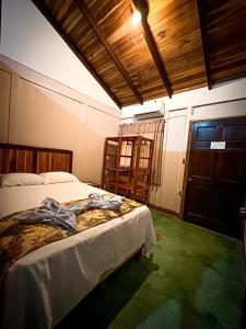 1 dormitorio con cama y techo de madera en Cabinas Tropicales, en Puerto Jiménez