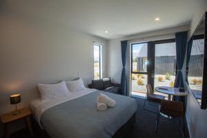 a hotel room with a bed and a large window at Luminous Tekapo in Lake Tekapo