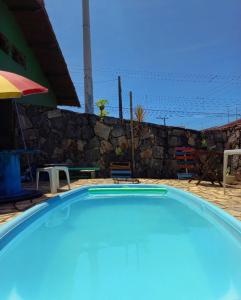 una gran piscina azul junto a una pared de piedra en Da Lua Hostel, en Ubatuba