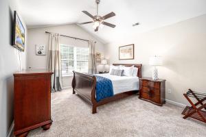 Un dormitorio con una cama y un ventilador de techo. en Cozy Pet friendly home-Raleigh, en Raleigh