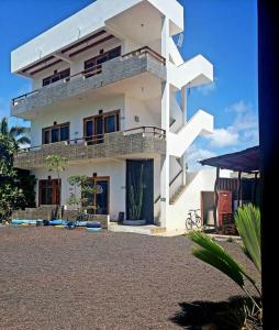 ein großes weißes Gebäude mit einer Treppe davor in der Unterkunft HOSPEDAJE DELFIN AZUL in Puerto Villamil