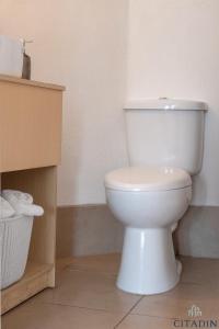 a bathroom with a white toilet in a room at Hotel Citadin in Guatemala