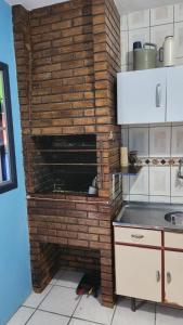 einen Backsteinofen in einer Küche mit Ziegelwand in der Unterkunft Apartamento de 6a8 P Churrasqueira in Cidreira