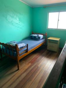Schlafzimmer mit einem Bett mit blauer Wand in der Unterkunft Apartamento de 6a8 P Churrasqueira in Cidreira