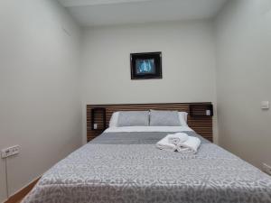 a bedroom with a bed with two towels on it at Apartamento en Gran Vía in Bilbao