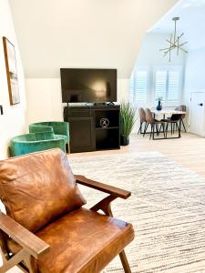 sala de estar con silla y TV de pantalla plana en New Haven Inn en Solvang