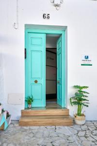 蘇西羅斯的住宿－El Deseo，白色建筑中一扇蓝色门,上面有植物