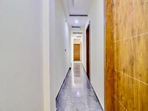 korytarz z długim przejściem z drewnianymi drzwiami w obiekcie Hotel Taj Star by Urban stay w mieście Agra