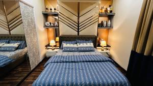 a bedroom with two beds and a mirror at Sky Heights Luxury Apartments Facing Centaurus Mall Islamabad in Islamabad