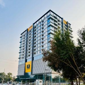 a tall building with a yellow and blue at Sky Heights Luxury Apartments Facing Centaurus Mall Islamabad in Islamabad