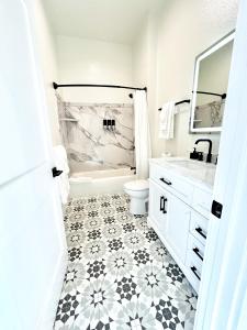 a white bathroom with a black and white tile floor at New Haven Inn in Solvang +96 photos