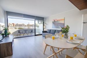 a dining room and living room with a table and chairs at Lovely 3BD 150m Beach Ocean View AC Wi-Fi Balcony in Albufeira