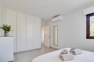 um quarto branco com toalhas numa cama em Lovely 3BD 150m Beach Ocean View AC Wi-Fi Balcony em Albufeira