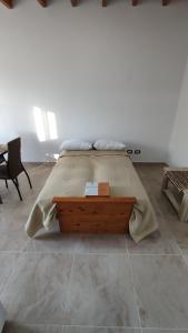 een slaapkamer met een groot bed en een houten tafel bij Las Cañas dpto in Guaymallen