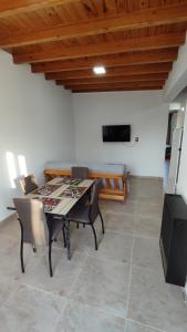 een eetkamer met een tafel, stoelen en een televisie bij Las Cañas dpto in Guaymallen