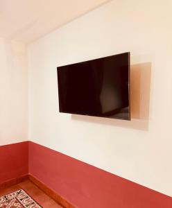 telewizor z płaskim ekranem wiszący na białej ścianie w obiekcie Lidia Anturios w mieście Oaxaca