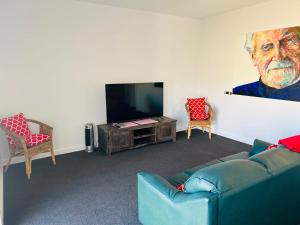 a living room with a couch and a flat screen tv at Sea Retreat - Esplanade Available Xmas 2023 and 2024 Summer in Robe