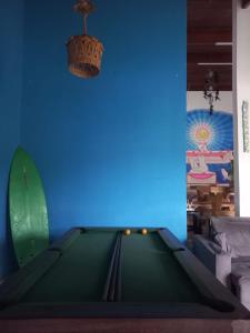 una mesa de billar en una sala de estar con una pared azul en Da Lua Hostel, en Ubatuba