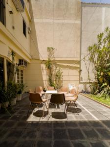 un patio con mesa y sillas frente a un edificio en Rodex Casa Boutique - Paraíso céntrico con pileta, terraza, asador en San Miguel de Tucumán