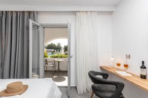 a bedroom with a bed and a table with two chairs at Naxos Resort Beach Hotel in Naxos Chora