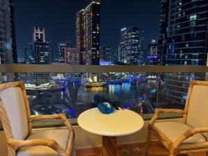 balcón con mesa, sillas y vistas al perfil urbano en Living Room JBR en Dubái