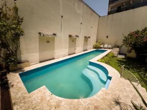 a swimming pool with blue water in a building at Rodex Hostel Tucuman in San Miguel de Tucumán