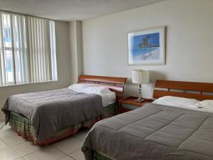 a hotel room with two beds and a window at Pavilion Beach Front Apartment with Balcony in Miami Beach