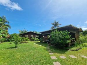 a house with a grass yard in front of it at Painapaopao Backpacker in Moorea