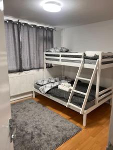two bunk beds in a room with a window at Stunning 2 Bedroom duplex in the Heart of London in London