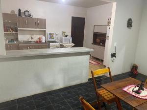 a kitchen and dining room with a table and a counter at Espaço confortável no centro da cidade in Foz do Iguaçu