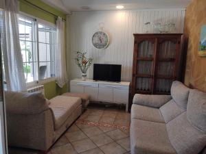 a living room with a couch and a tv at Villa Santos in Elche